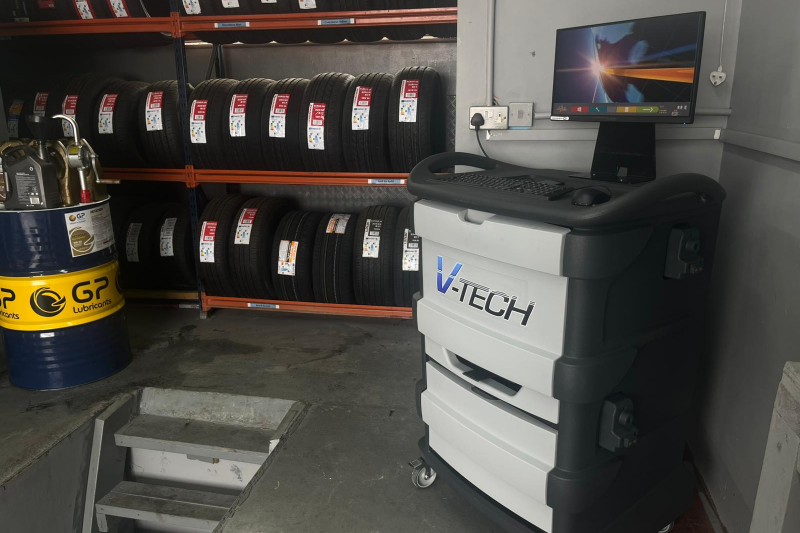 A Wheel Alignment Machine Kit with Bunch of Tyres in the background and tools